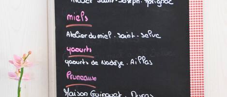 A breakfast setup with a menu board, fruits, and various breakfast items.