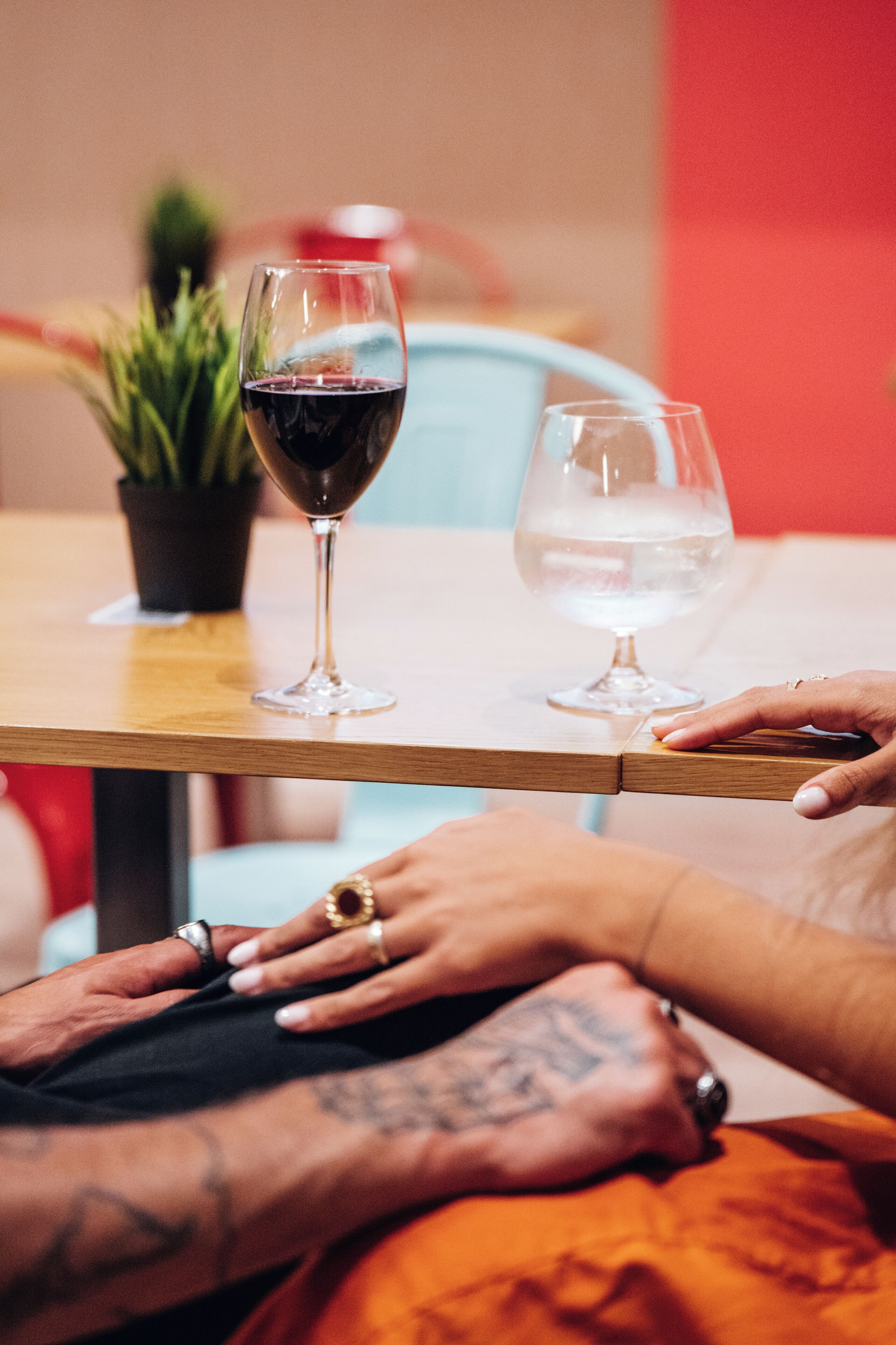 A table with two wine glasses, one filled with red wine and the other with white wine.
