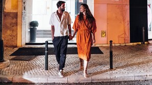 Una pareja caminando frente a un hotel con un letrero que dice 'STAY Just what you need'.