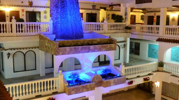 A multi-level courtyard with a central water feature, balconies, and a pool area. - Ona Las Rampas (Fuengirola)