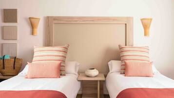 Una cama doble con cabecera de madera, dos mesitas de noche, una cesta tejida y un florero sobre una de las mesitas.