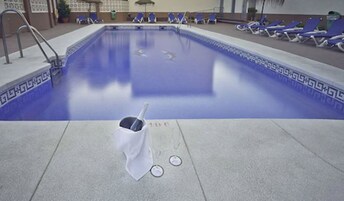 A swimming pool with lounge chairs and a lifebuoy on the deck.