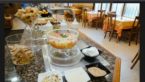 A buffet setup with various food items and a decorative bowl. - Ona Las Rampas (Fuengirola)