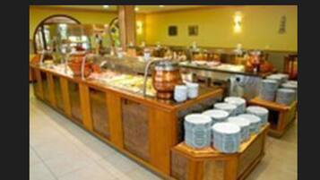 Zona de bufé con diversos alimentos y recipientes.