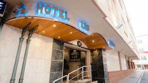 The exterior of Hotel Las Rápidas with a curved entrance, a sign above the door, and a staircase leading up to the entrance. - Ona Las Rampas (Fuengirola)