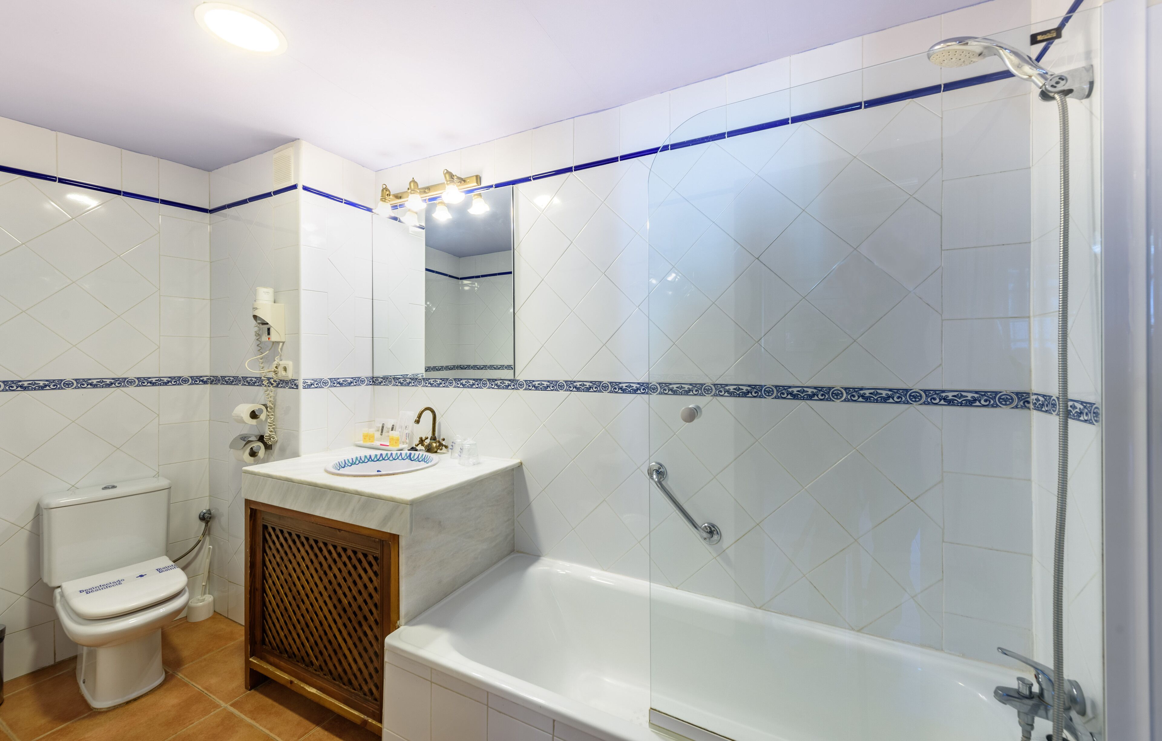 A bathroom with a toilet, sink, and bathtub.