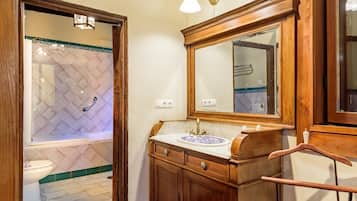 Un baño con tocador de madera, un espejo grande y una ducha con pared de azulejos estampada con diseño de diamantes.