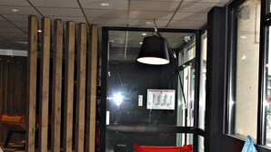 Ein modernes Interieur mit einer Sitzecke, ausgestattet mit roten und blauen Kissen, grauen Sitzsäcken und einem gemusterten Teppich.
