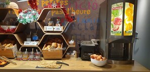 Een ontbijtbuffet met diverse gerechten en een koffieapparaat.