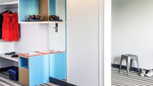 A modern bathroom with a mirror, towel rack, and a small stool. - ibis Styles Antony Paris Sud (Antony)