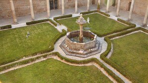 A courtyard with a central fountain, surrounded by neatly trimmed hedges and stone columns. - Eurostars Monumento Monasterio de San Clodio Hotel (Leiro)
