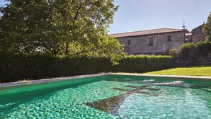 A clear swimming pool with a stone building in the background. - Eurostars Monumento Monasterio de San Clodio Hotel (Leiro)