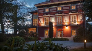 A large, two-story building with a symmetrical facade, multiple windows, and a central entrance. - Casona de la Paca (Cudillero)