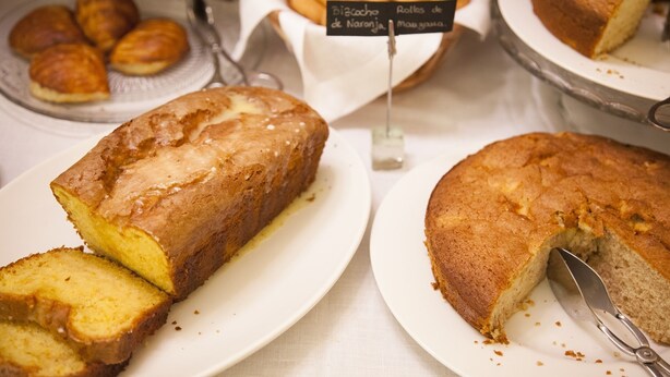 A display of baked goods including a loaf of bread and pastries on plates. - Casona de la Paca (Cudillero)