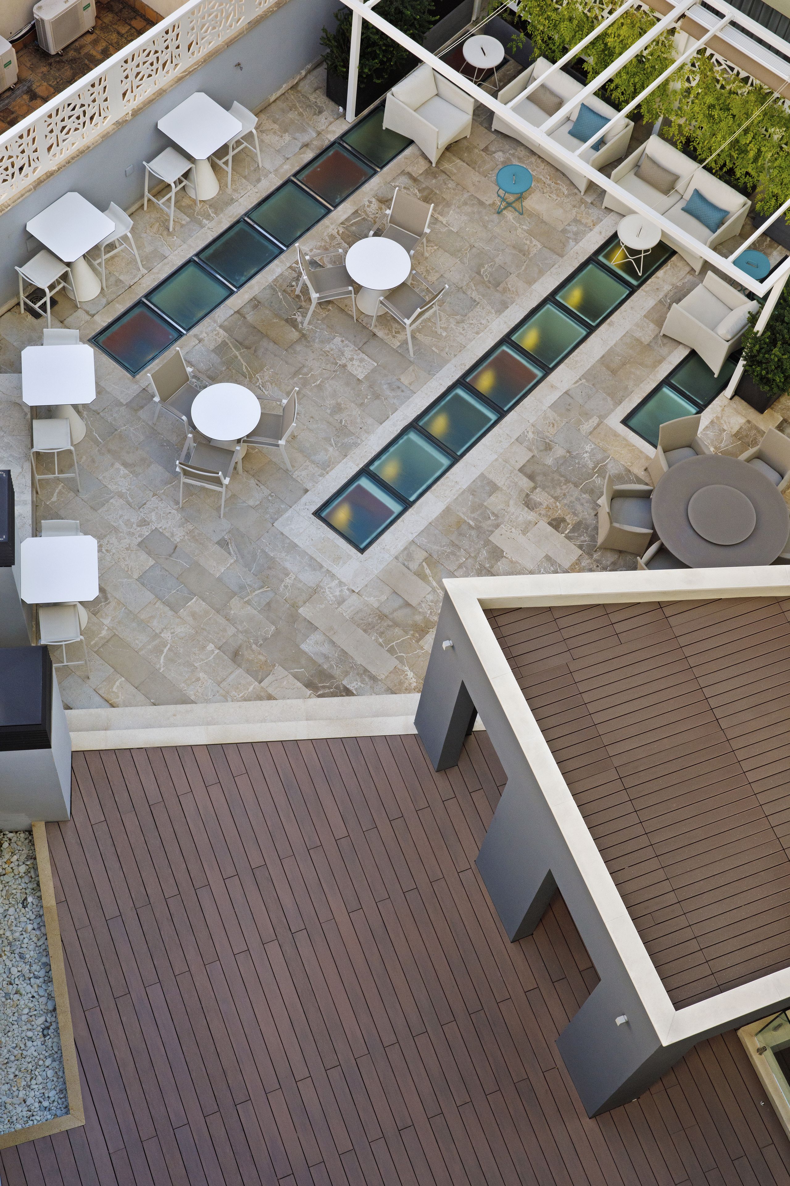 A rooftop patio with outdoor seating, a pool, and a wooden deck.