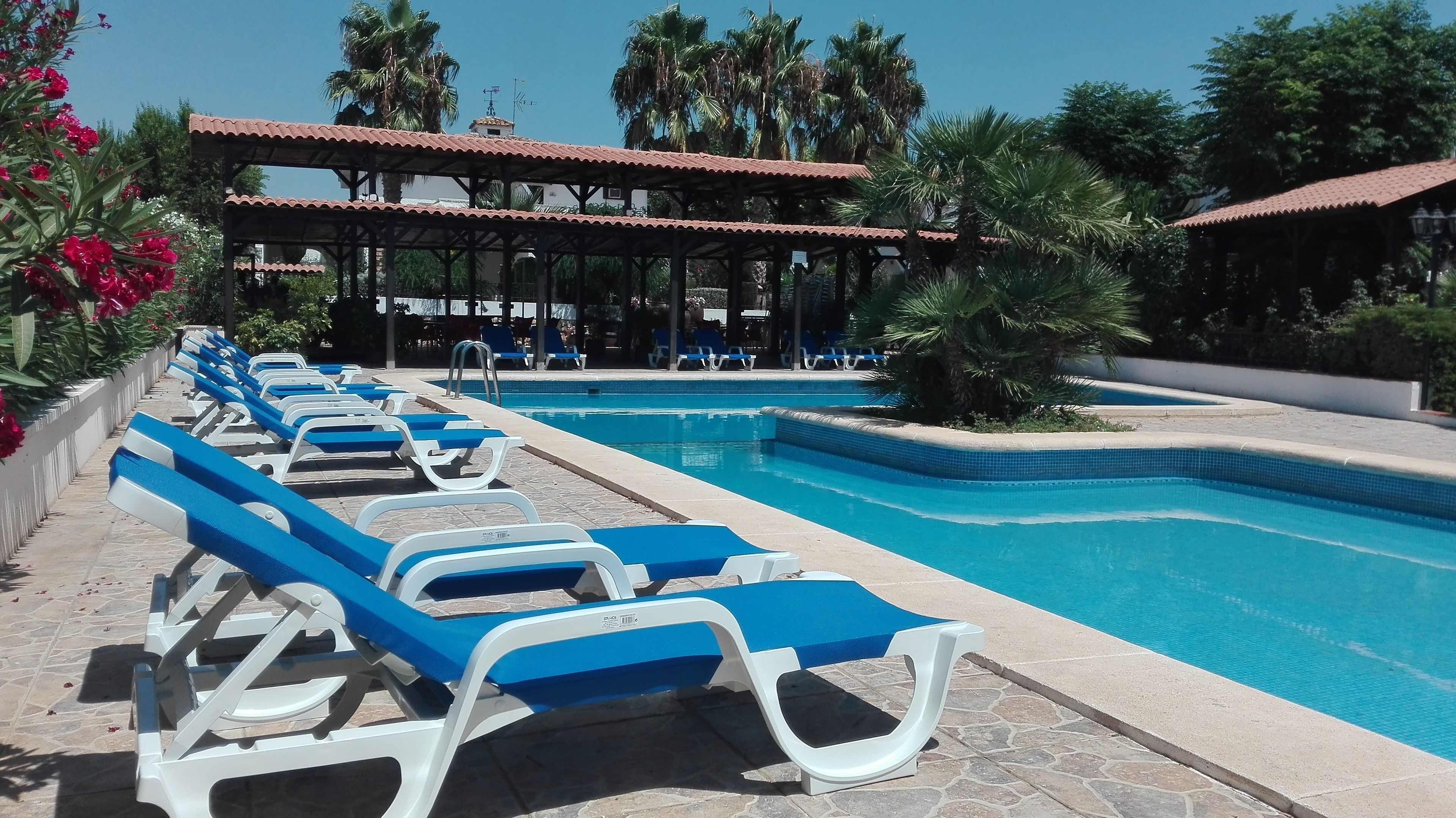 Een buitenzwembad en ligstoelen