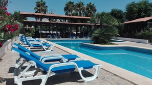 Een buitenzwembad en ligstoelen