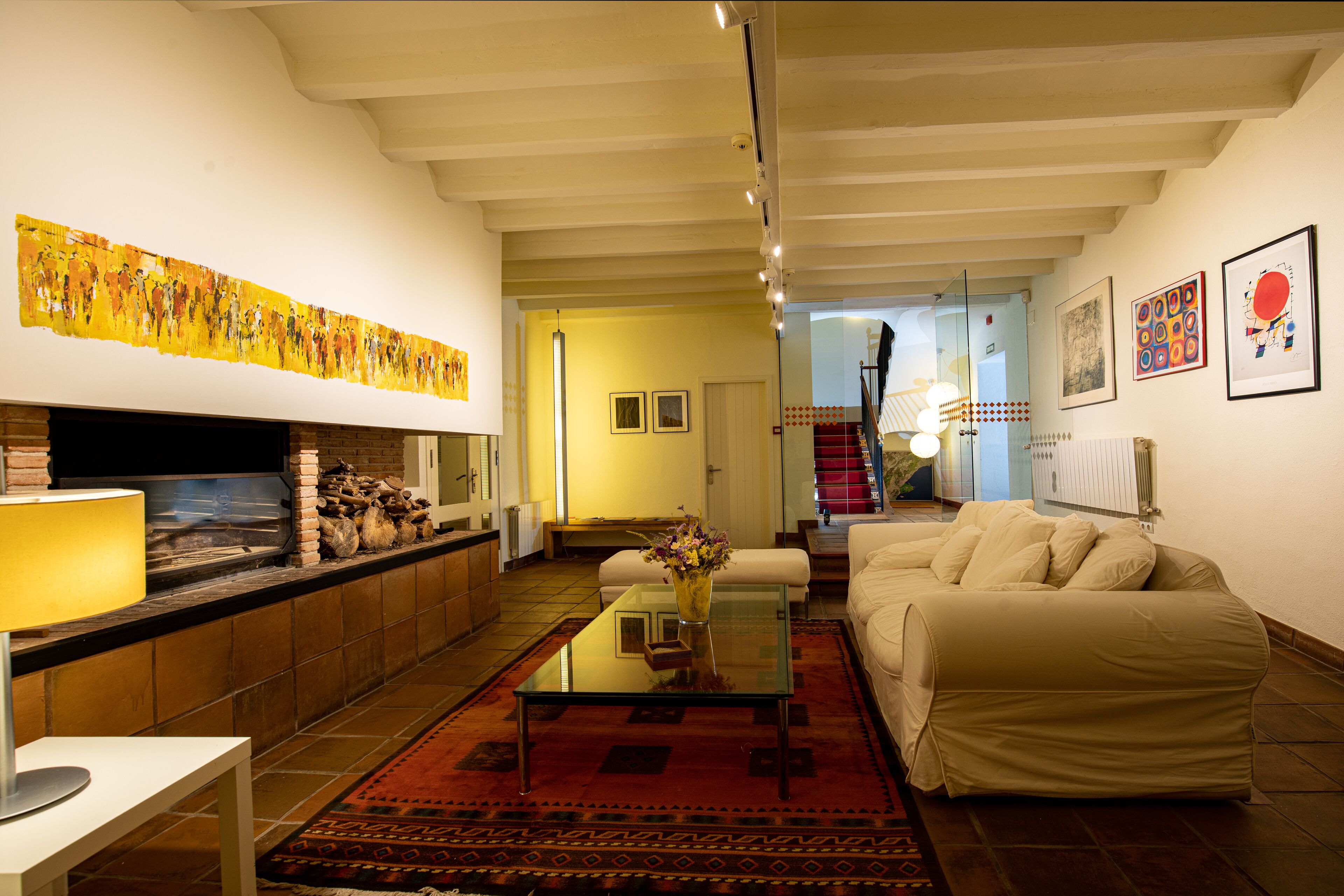 A spacious living room with a fireplace, a sofa, a coffee table, and a rug.