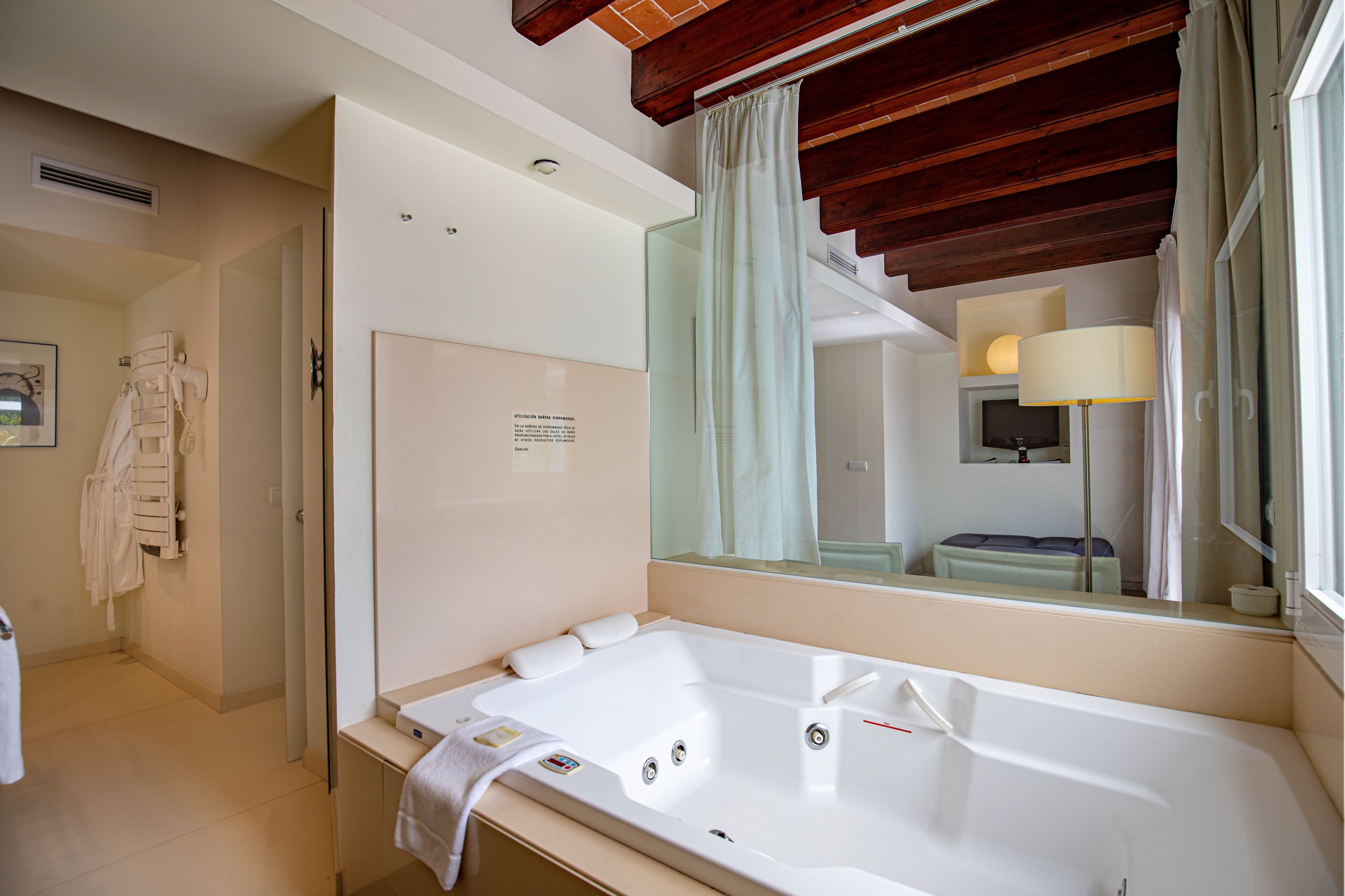 Une salle de bain moderne avec une grande baignoire, un miroir et un espace douche.
