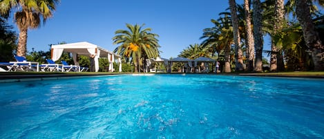 Una piscina al aire libre, tumbonas