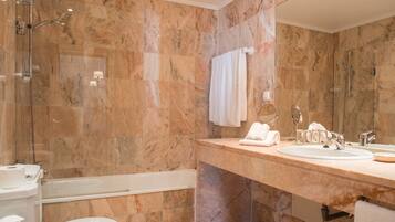 Ein modernes Badezimmer mit einer Badewanne, einer Toilette und einem Waschbecken mit Spiegel.