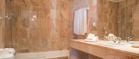 A modern bathroom with a bathtub, a toilet, and a sink with a mirror.