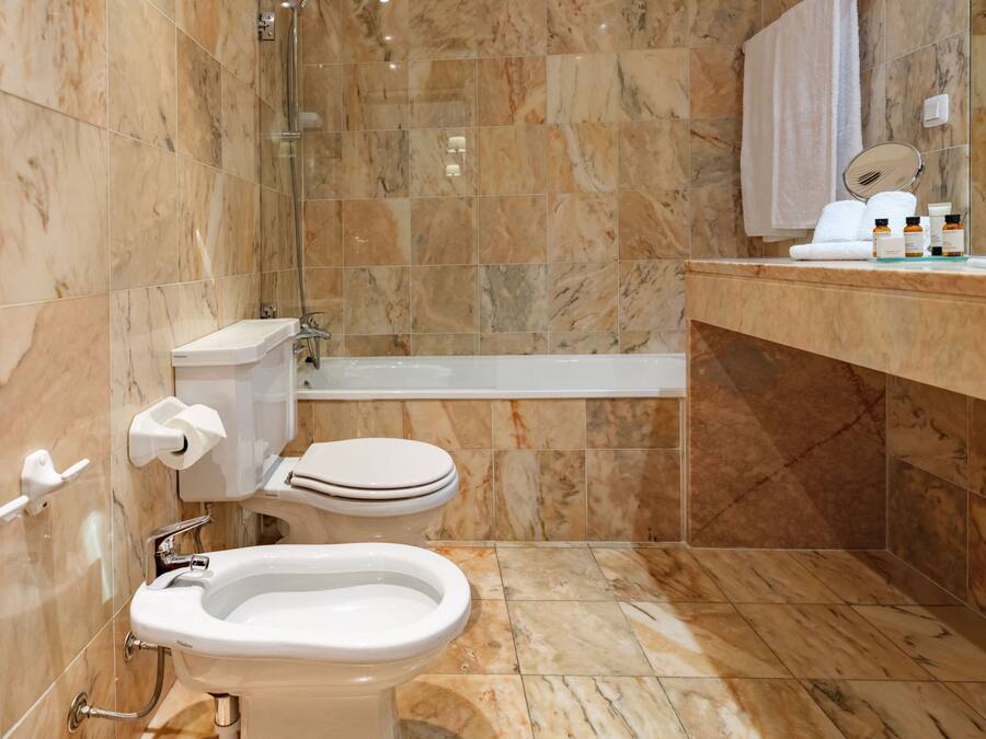 Un baño con inodoro, bidé y bañera.