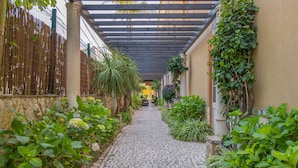 A cobblestone pathway flanked by lush greenery and a bamboo fence. - Charming Residence & Guest House Dom Manuel I (Adults only) (Lagos)