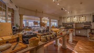 A buffet area with various food items, baskets, and a counter with a knife.
