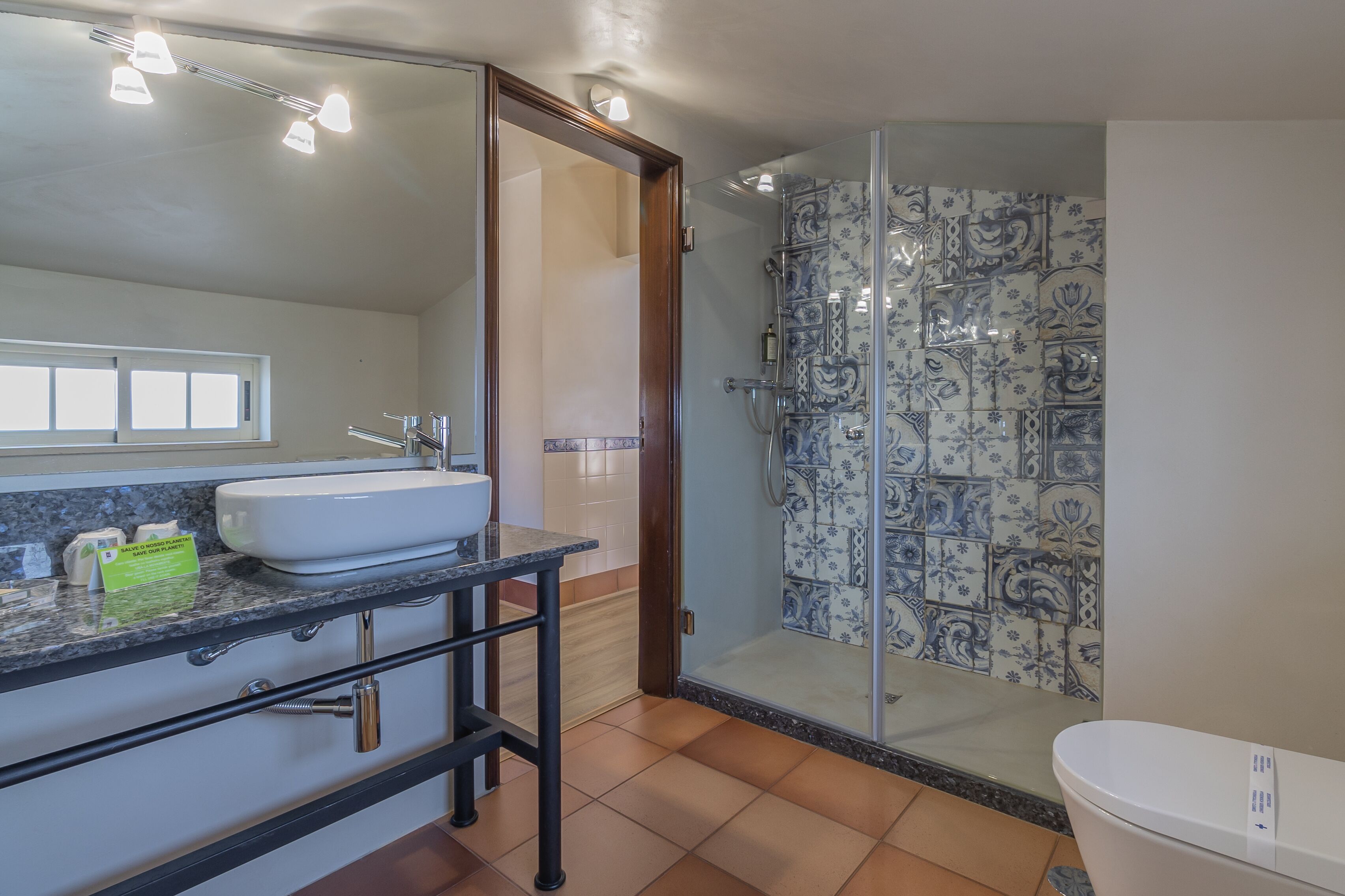 A bathroom with a white sink, a glass shower enclosure, and a toilet.