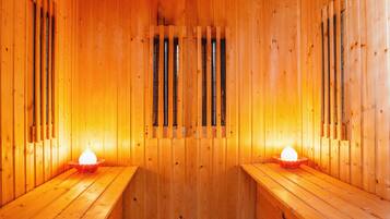 Una sauna de madera con bancos y un pasillo central.