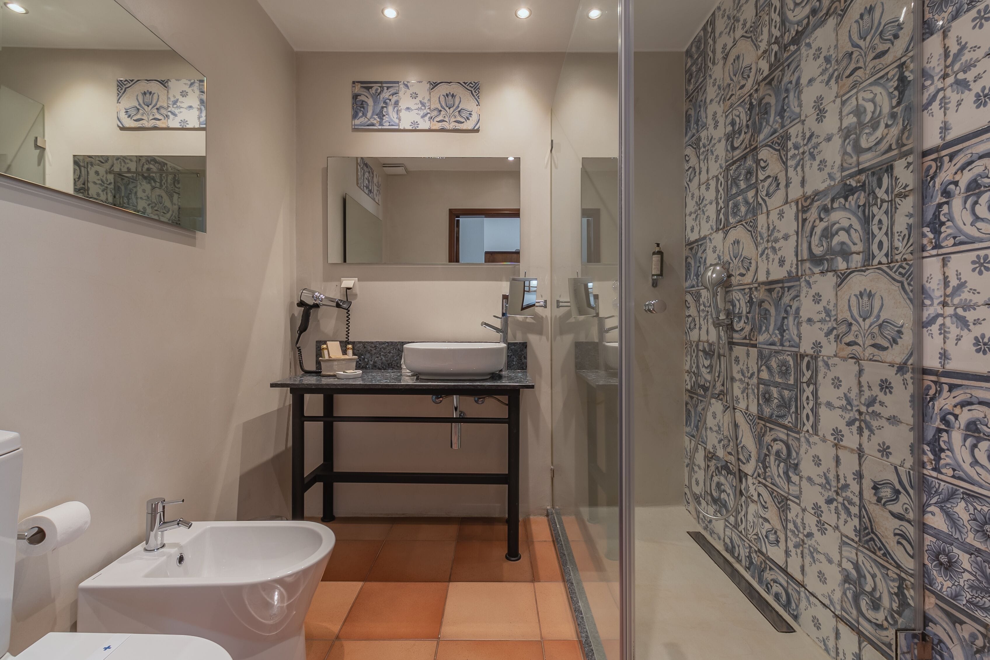 A bathroom with a white sink, a freestanding bathtub, and a glass shower enclosure.