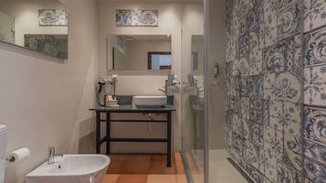 A bathroom with a white sink, a freestanding bathtub, and a glass shower enclosure.