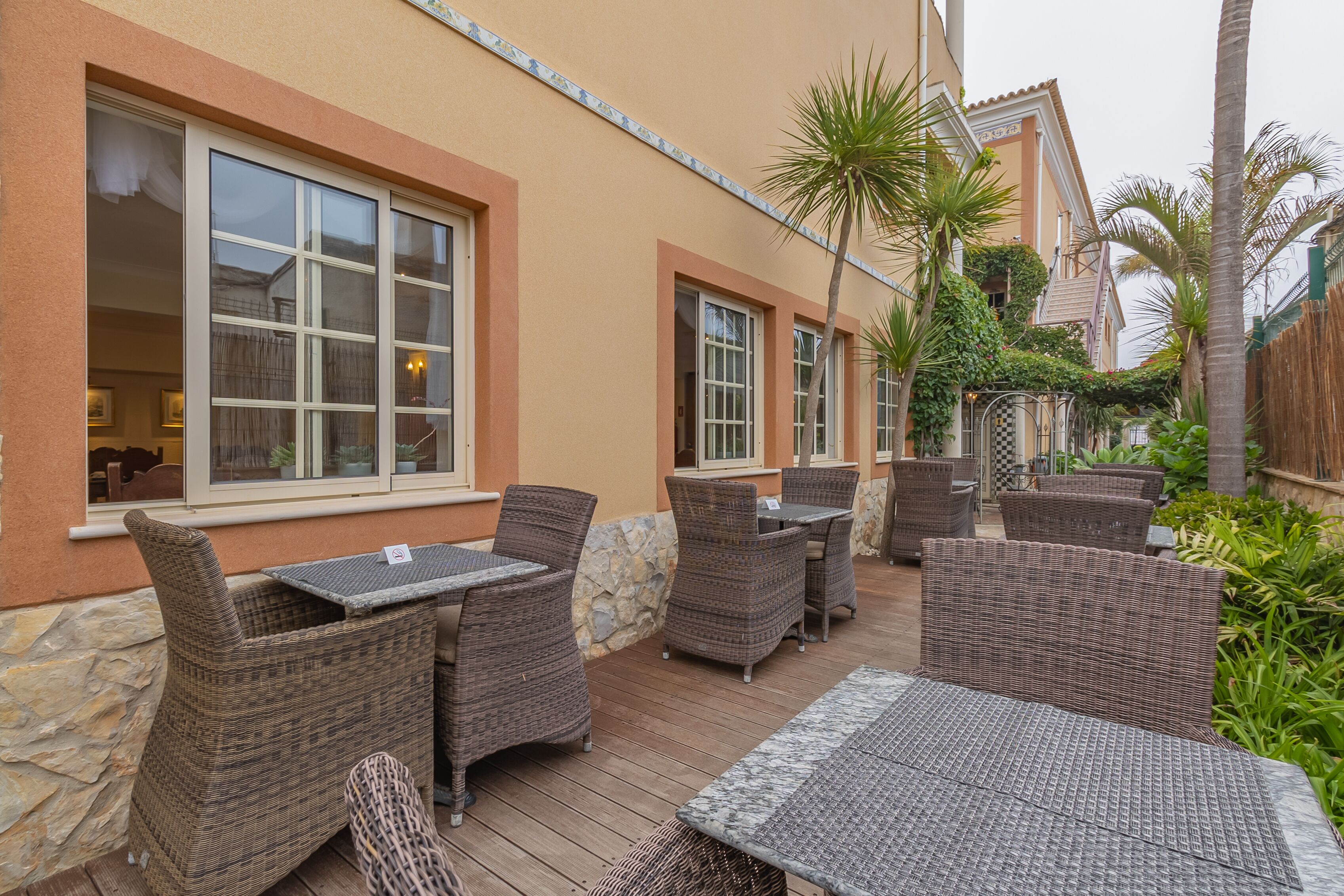 An outdoor patio with wicker furniture and stone accents.