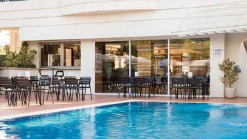 Alberca al aire libre y camastros
