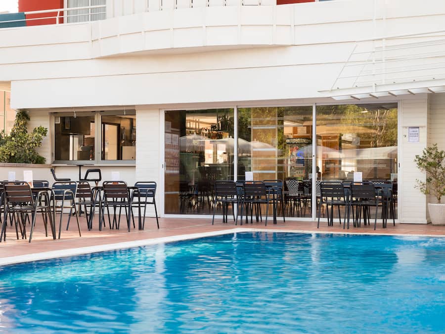 Una piscina al aire libre, sillones reclinables de piscina