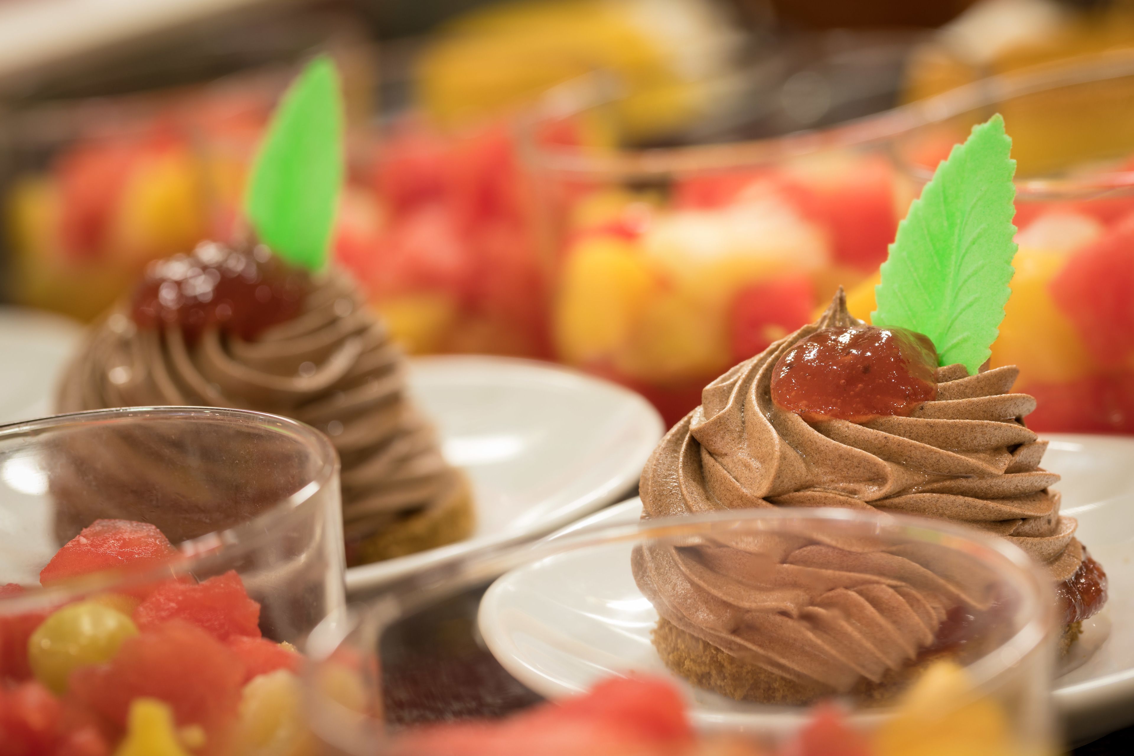 Una mesa de postres con diversos dulces y fruta.