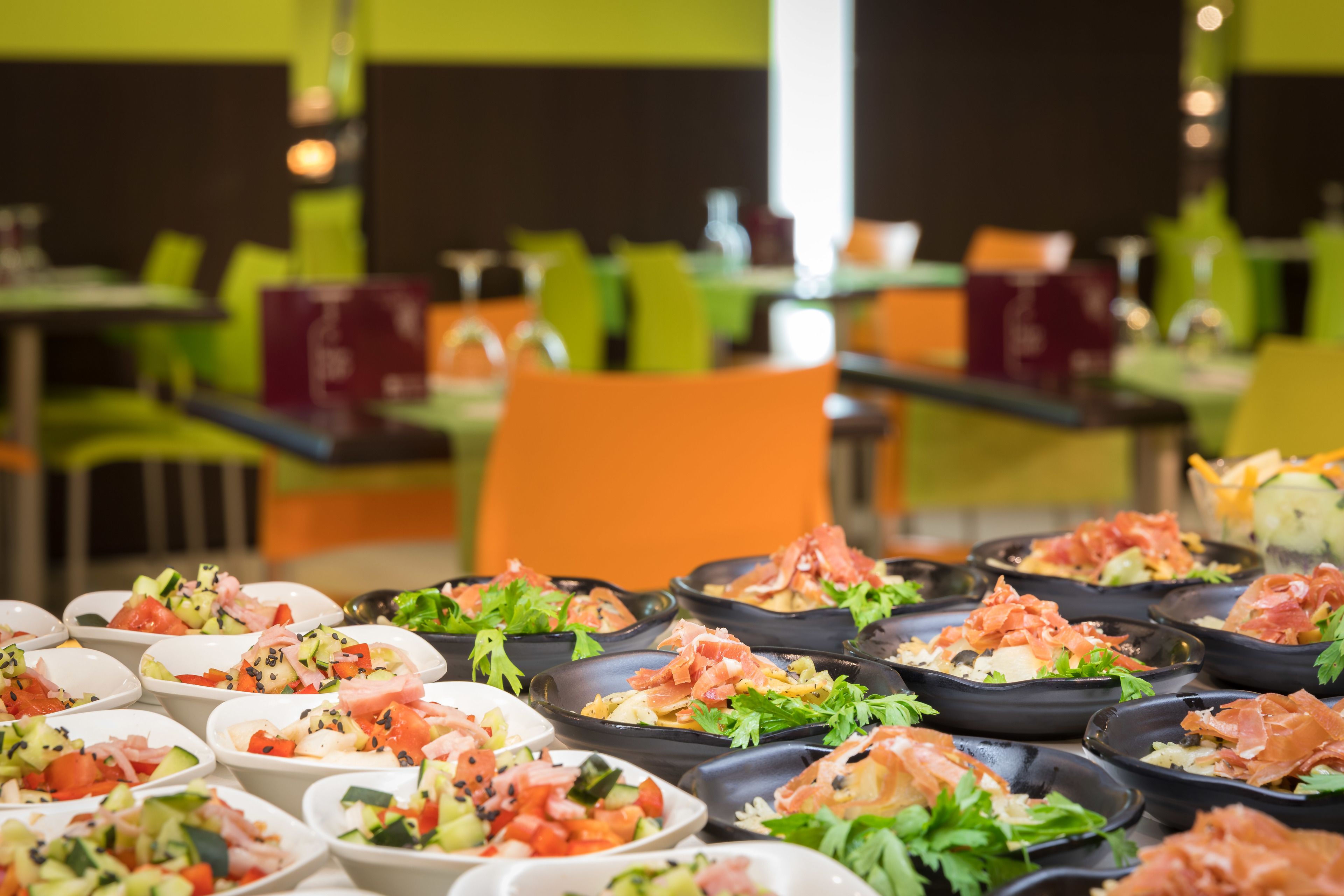 A buffet with various dishes, including salads and seafood, arranged on black serving platters.