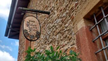 Un edificio rústico con fachada de piedra y un letrero colgante que dice "Palacio de la Luna".