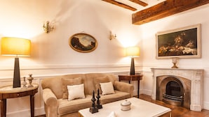 A cozy living room with a beige sofa, two side tables with lamps, a fireplace, and framed artwork on the walls. - Salinas de Imon (Siguenza)