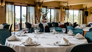 A restaurant with tables set for dining, featuring a central vase with flowers. - Rural Los Nogales (Pozo Alcon)