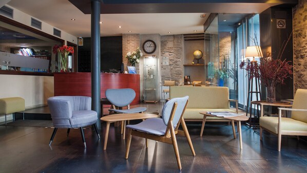 A hotel lobby with seating areas, a reception desk, a clock, and a globe. - Hotel Abad Toledo (Toledo)