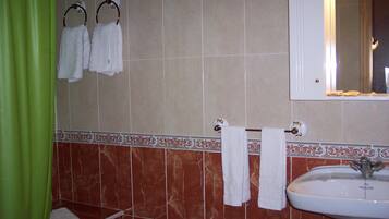 A bathroom with a sink, a mirror, and two towel racks with white towels.