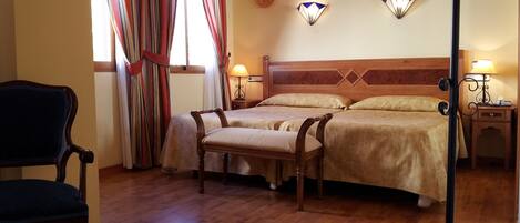A hotel room with a wooden bed, two bedside tables with lamps, a chair, and a large window with curtains.