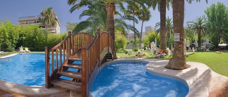 Una piscina al aire libre, sombrillas, tumbonas