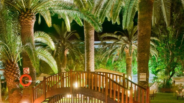 Una piscina al aire libre, sombrillas, tumbonas