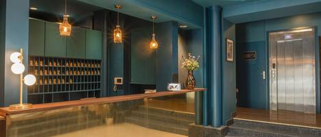 A reception area with a wooden counter, a glass display case, and a vase with flowers.