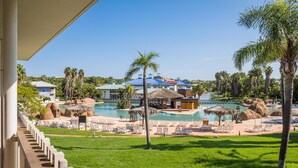 A resort with a pool area, palm trees, and a building with a blue roof. - PortAventura Hotel Caribe - Includes unlimited access to PortAventura Park & 1 day access to Ferrari Land (Salou)