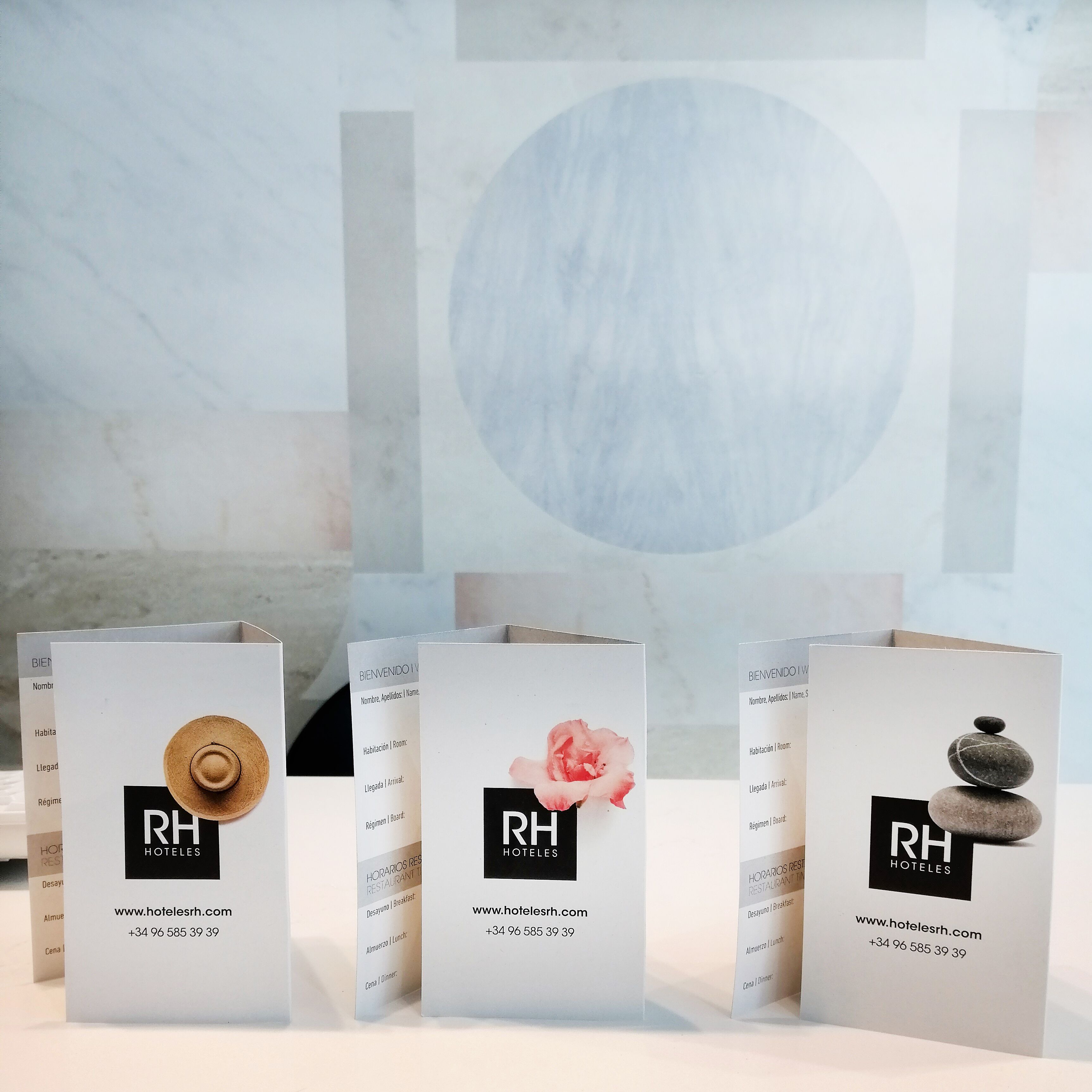 Tres tarjetas de bienvenida de hotel con el logotipo 'RH HOTELS' e información de contacto.