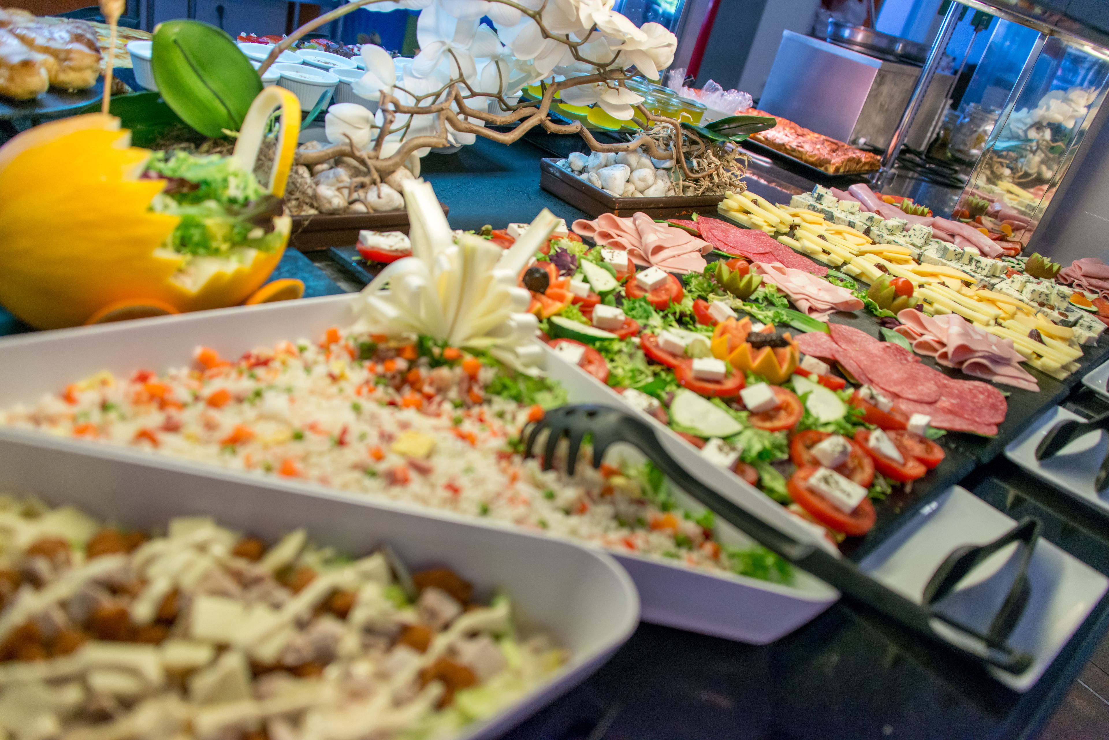 Ein Buffet mit verschiedenen Speisen, darunter Salate, Fleischgerichte und Reis.